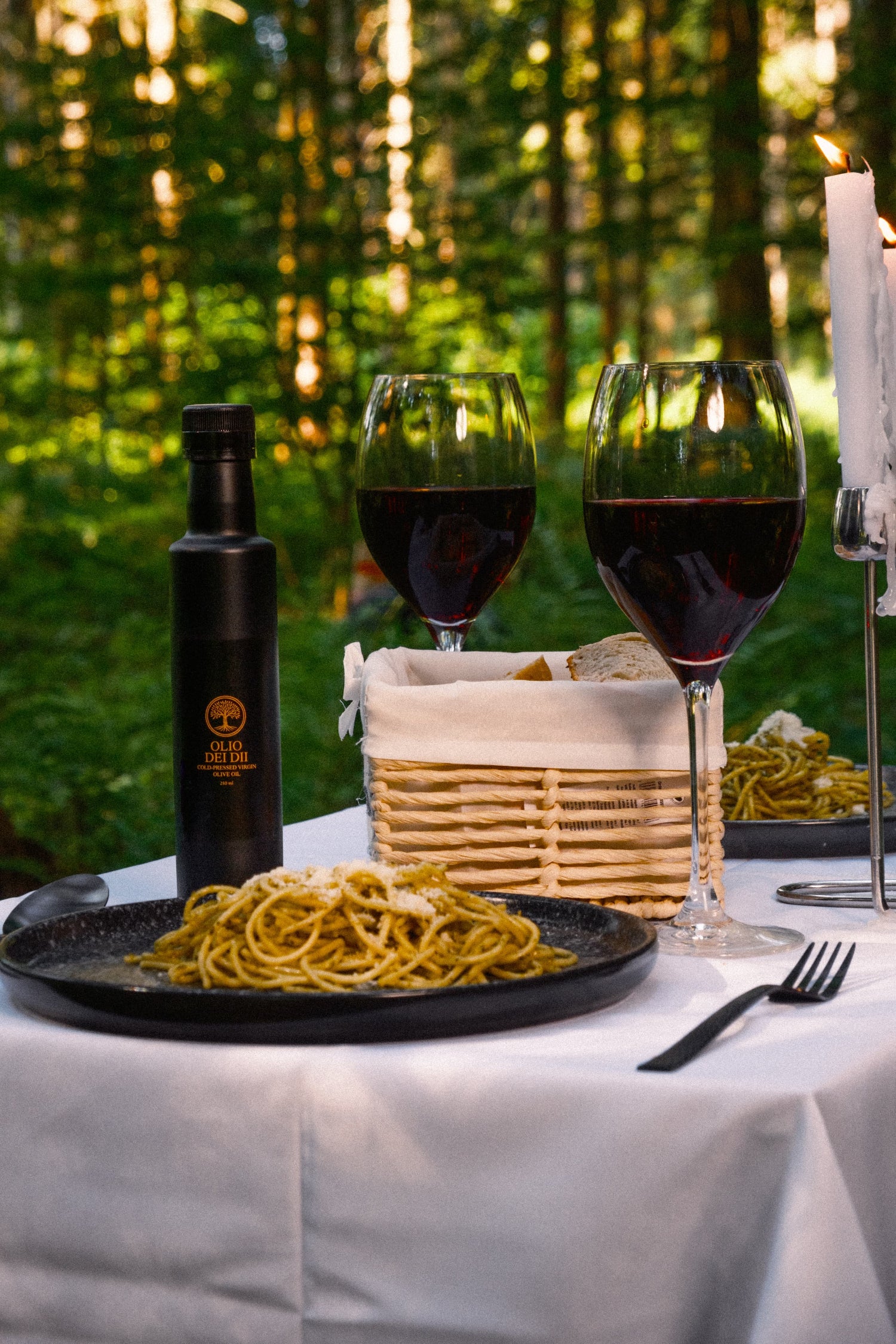 Premium Olivenöl aus Kalabrien serviert mit Wein und Spaghetti im Wald